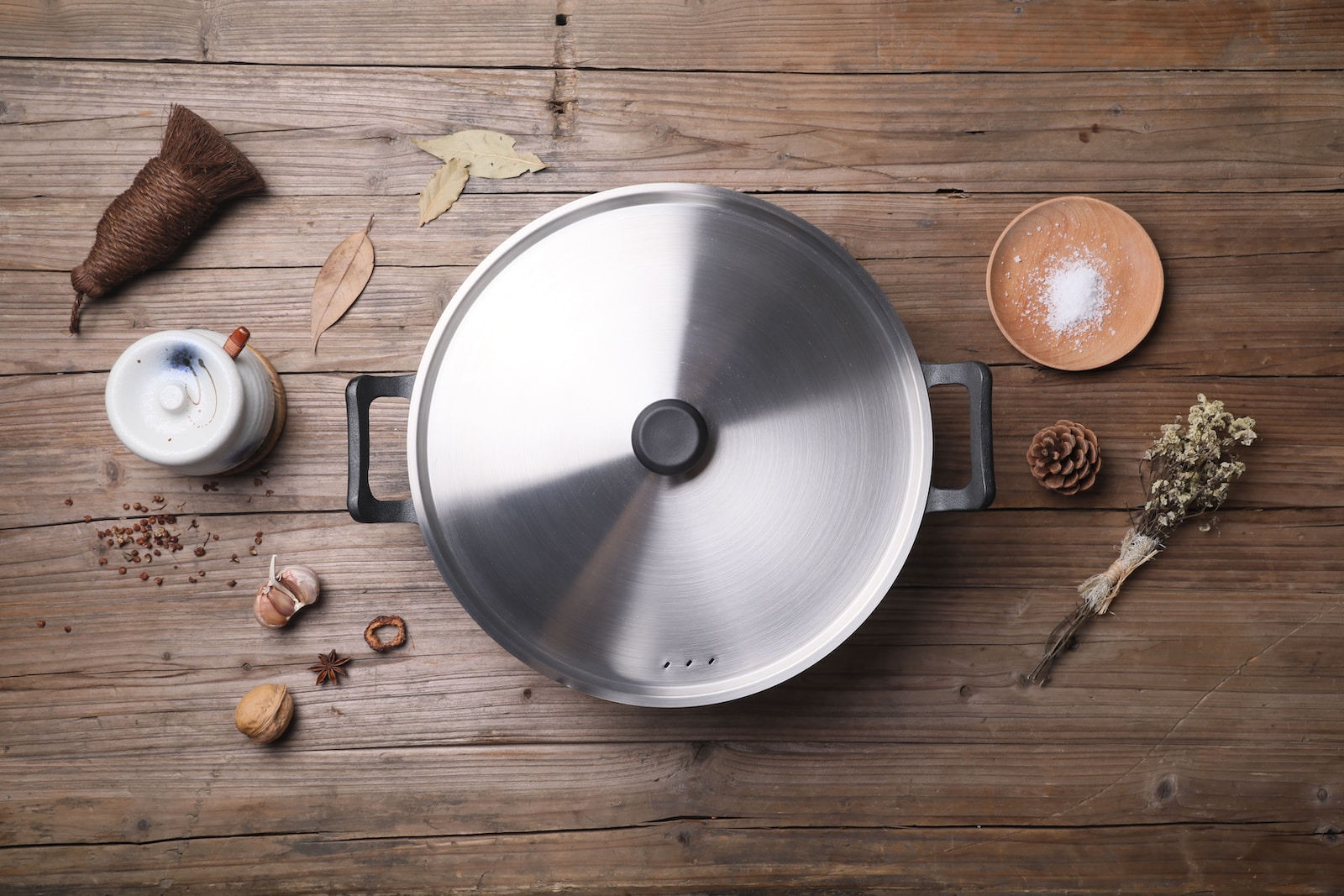 stainless steel cooking pot beside brown round fruit on brown wooden table